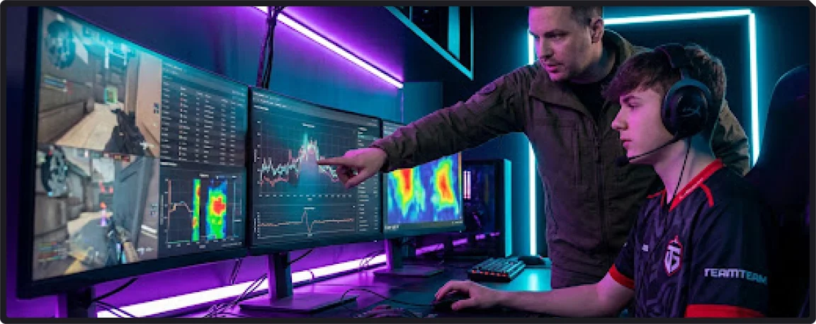 Treinador de eSports apontando para gráficos e estatísticas em um monitor enquanto orienta um jovem jogador em uma sala de treino futurista